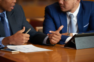 Two professionals talking with a backdrop of a court and discussing expert witness