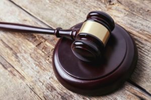 A gavel is banged onto the table in the court room.