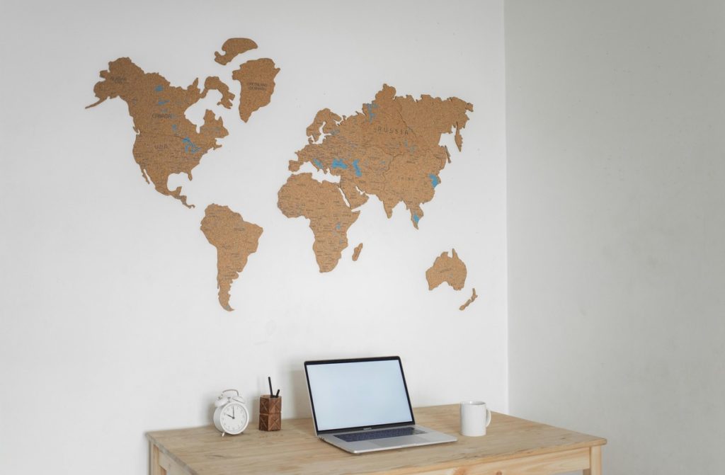 world-map-on-wakk-and-laptop-on-table