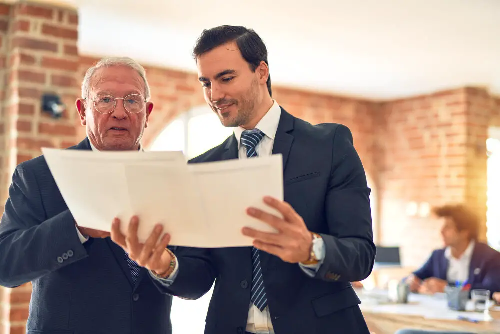 two-business-workers-working-together-speaking-reading