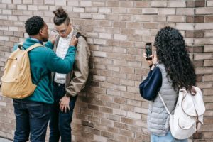 picture of a person bullying a classmate near a building