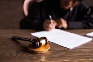 A picture of judge signing on papers