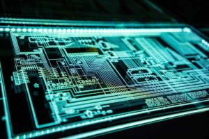 Close-up-of-a-glowing-computer-screen-displaying-a-complex-electronic-circuit-board-layout.