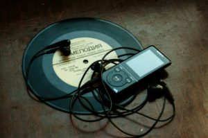 in-ear-headphones-plugged-in-black-sony-walkman-on-vinyl-record