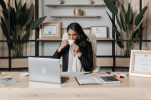 a-woman-drinking-coffee-while-sitting-in-the-office