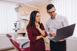 Dentist discussing care plan with patient in dental clinic.