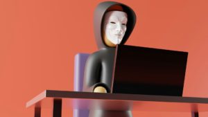 hooded-figure-in-mask-using-laptop