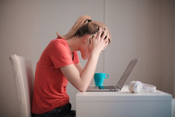 woman-in-red-t-shirt-looking-at-her-laptop