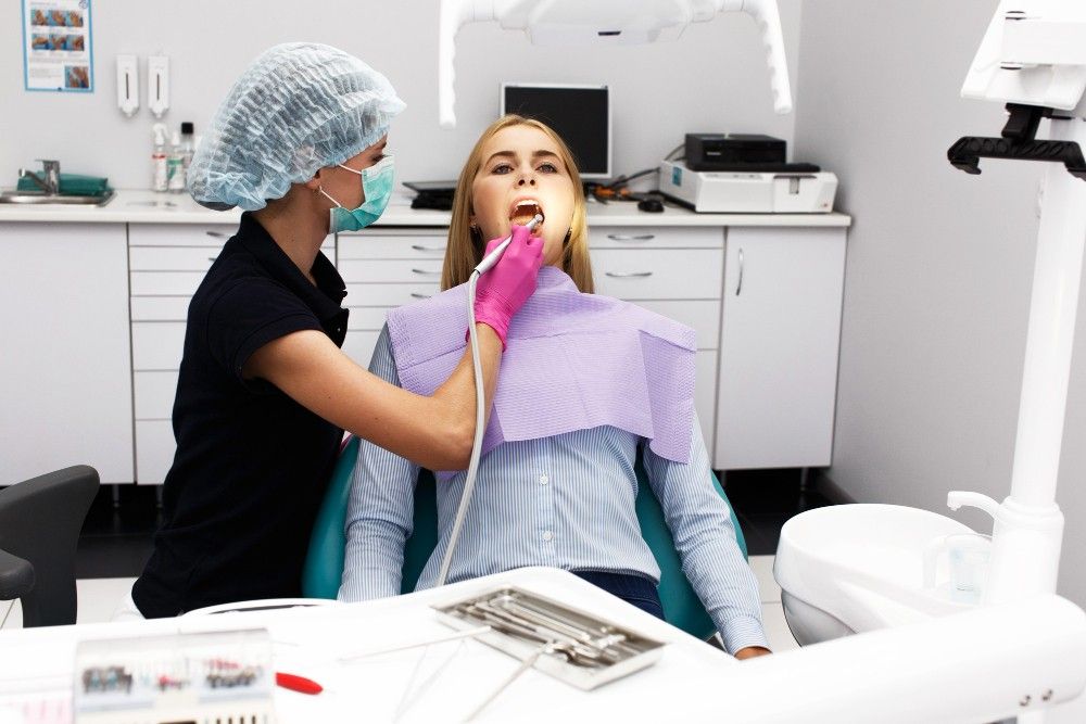 female-dentist-treating-her-patient-teeth
