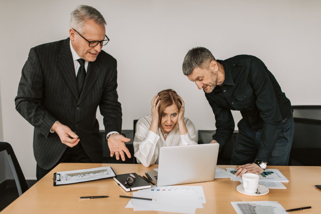 Business executives reacting to a reputation crisis while reviewing a laptop screen